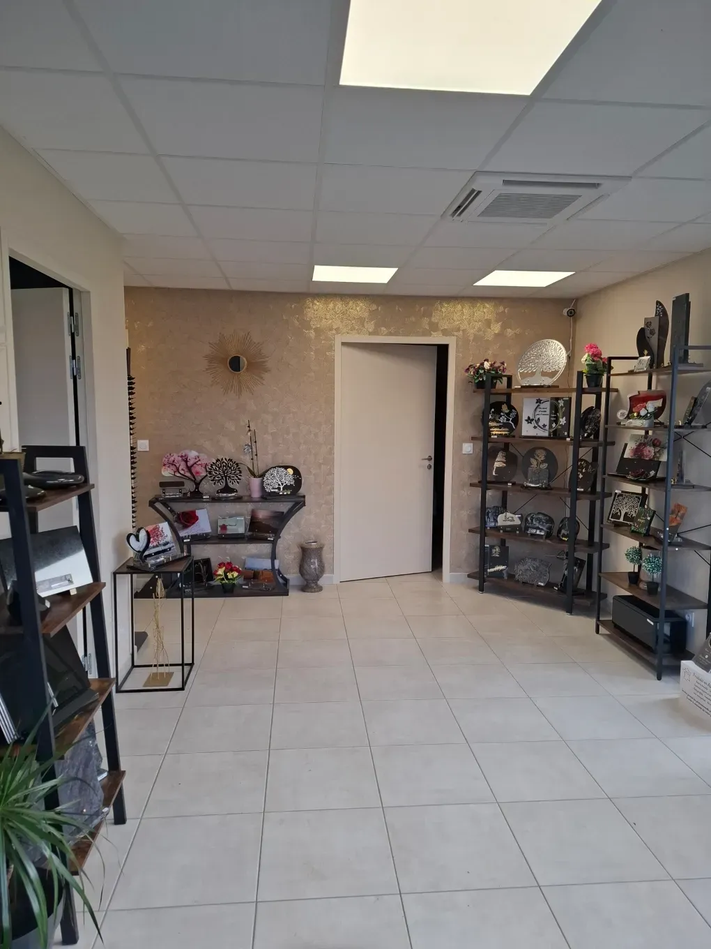 Showroom de marbrerie présentant des plaques funéraires et urnes commémoratives.